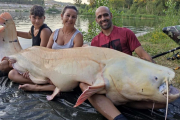 Juan Dalmau i la seva família amb el silur albí que han pescat al riu Ebre.