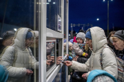 Una mujer entrega el pasaporte en la frontera entre Ucrania y Eslovaquia.