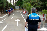 Tres joves circulant amb bicicleta pel parc infantil de trànsit.