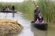 Els visitants passejant en una en barca durant la festa de l'arròs de Deltebre.