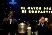 Dos niñas de Sant Ildefons con uno de los números premiados en la Rifa de Navidad de 2017.