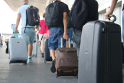 Turistes amb maletes a la sortida de l'aeroport de Reus.