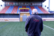 Un membre del club de futbol de Camarles mirant el crespó negre col·locat a les grades.