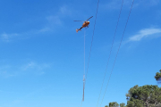 Operaris d'Endesa fent tasques de manteniment en una zona boscosa del Priorat amb la intervenció d'un helicòpter.