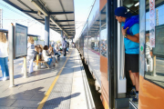 Un usuari treu el cap en un tren de Rodalies aturat a l'estació de Gavà.