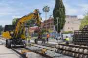 La grua amuntegant les travesses ahir al matí, en la part del traçat pròxim a l'antiga estació.