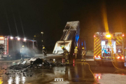 Els bombers apagant el foc de les restes d'escombraries a la plaça dels Carros.