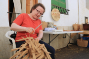 Una cistellera elabora una bossa feta amb fibres de paper.