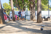 Alguns participants aprofiten per exercitar-se a l'ombra dels arbres, entre les pistes i el local social.