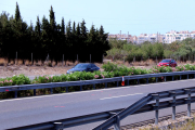 Imágenes del tramo de la autopista AP-7 con marcas de la investigación del accidente por parte de los Mossos y el casco urbano de L'Ametlla de Mar, al fondo.