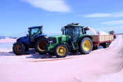 Màquines i tractors recollint la sal a les salines de la Trinitat, al delta de l'Ebre.