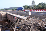 Brossa acumulada al costat del viaducte del canal de la Dreta de l'Ebre sobre el barranc de la Galera i trànsit per la C-12, al fons.