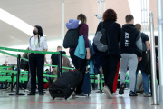 Passatgers a l'aeroport del Prat en direcció a la zona d'embarcament.