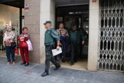 Dos agents de la Guàrdia Civil sortint amb un detingut en un dels registres fets a Tarragona l'operatiu policial conjunt amb els Mossos d'Esquadra.