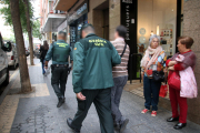 Dos policies de la Guàrdia Civil sortint amb un detingut en un dels registres fets a Tarragonal'operatiu policial conjunt amb els Mossos d'Esquadra.