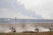 Soldados israelíes en vehículos militares recorren un área a lo largo de la frontera con Gaza