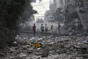 Un grup de palestins en una zona arrasada pels atacs israelians a Gaza.