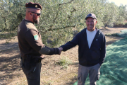 El guarda rural de Constantí saluda a un campesino del pueblo que hace la cosecha de aceitunas.