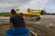 Un operari, durant el repostatge d'una de les avionetes encarregades del tractament contra les larves de mosquit al Delta.