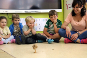 Alumnes d'una escola observen un pollet a classe.