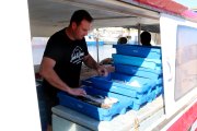 Un pescador preparant el peix a la barca per entrar-lo a la llotja de l'Ametlla de Mar.