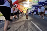 Dues nenes juguen sota una bandera multicolor durant el Pride Barcelona