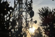 Una part de les antenes d'una torre de telecomunicacions amb el sol a punt de pondre's