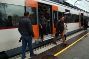 Usuaris baixant i agafant un tren de l'R2 Sud arribant a l'estació de Calafell