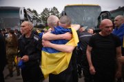 Presoners ucraïnesos intercanviats arran de l'acord entre Rússia i Ucraïna s'abracen al ser alliberats, portant a sobre una bandera ucraïnesa