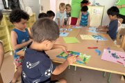 Imatge del grup de petits del casal de la Fundació Pere Tarrés a l’Escola Saavedra, treballant amb plastilina.