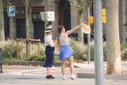 Dues turistes amb barrets durant el pic de l'onada de calor aquest diumenge a Barcelona