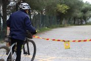 Un ciclista llegint el cartell que indica la prohibició d'accedir a Collserola a la carretera de les Aigües de Barcelona.
