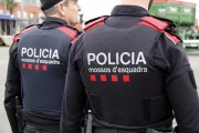 Esquena de dos agents dels Mossos d'Esquadra patrullant