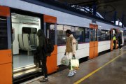 Viatgers pujant a un tren de Rodalies a l'estació de Lleida.