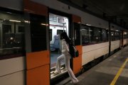 Una viatgera puja a un tren de la RL3 a l'estació de Lleida-Pirineus.