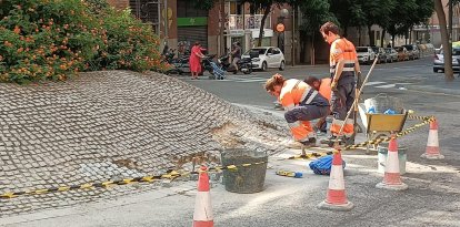 Operaris de la brigada municipal realitzant les tasques de manteniment a la rotonda de Pere Martell.