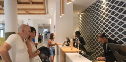 Uns turistes esperen ser atesos a la recepció de l'hotel Blaumar de Salou