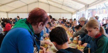 Una mestra xatonaire ajuda a un nen durant la 40a edició de la Xatonada del Vendrell