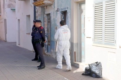 Agents de seguretat ciutadana vigilen l'exterior del domicili de Torredembarra on han trobat mort un home.
