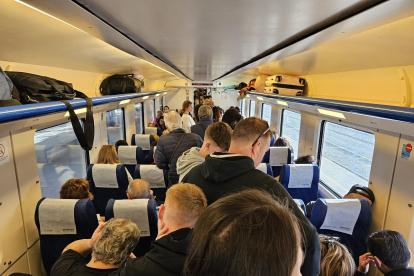 Imatge d'un tren, amb parada a Tarragona, ple de passatgers.