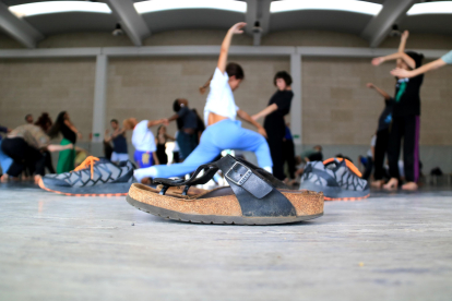 Primer pla d'unes sabates davant d'un grup de ballarins fan classe a Deltebre Dansa.