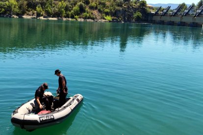Una barca de la unitat subaquàtica dels Mossos busca el cos del jove al pantà de Sant Antoni.