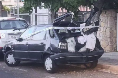 Un vehicle estacionat amb la part de darrere destrossada.