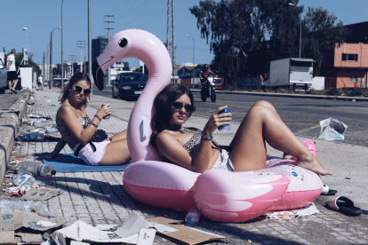 Dues joves de ressaca intenten gaudir de l’espera al bus en una imatge del projecte ‘Visit Tarragona: where history meets garbage’.
