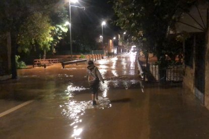 Un nen just abans del pont que dona accés al nucli dels Valentins i per sobre del qual ha saltat l'aigua del barranc.