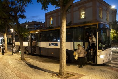 Fotografia de passatgers baixant d’un autobús a l’estació Reus Centre al vespre.