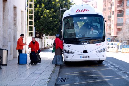 Viatgers agafant l'autobús ofert en el servei alternatiu per les obres de l'R17.