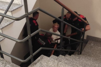Momento en el que los Mossos d'Esquadra subían a una señora por las escaleras.