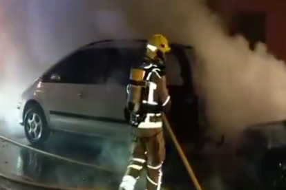Els bombers treballant en l'extinció del l'incendi dels dos vehicles.
