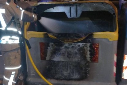 Un bomber treballant en un dels incendis de contenidors.